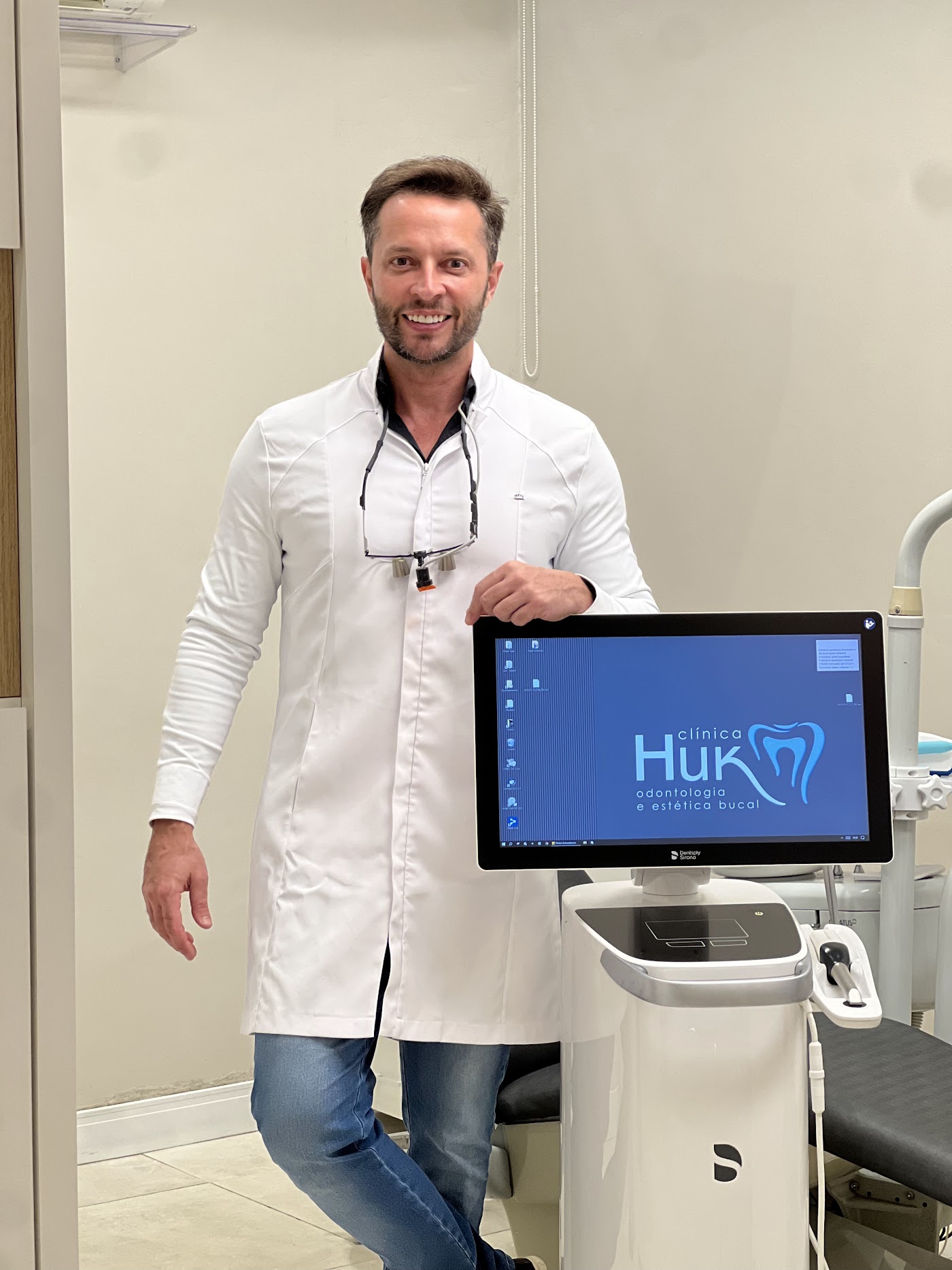 Dr. Daniel Huk ao lado da tela de planejamento digital na Clínica Huk