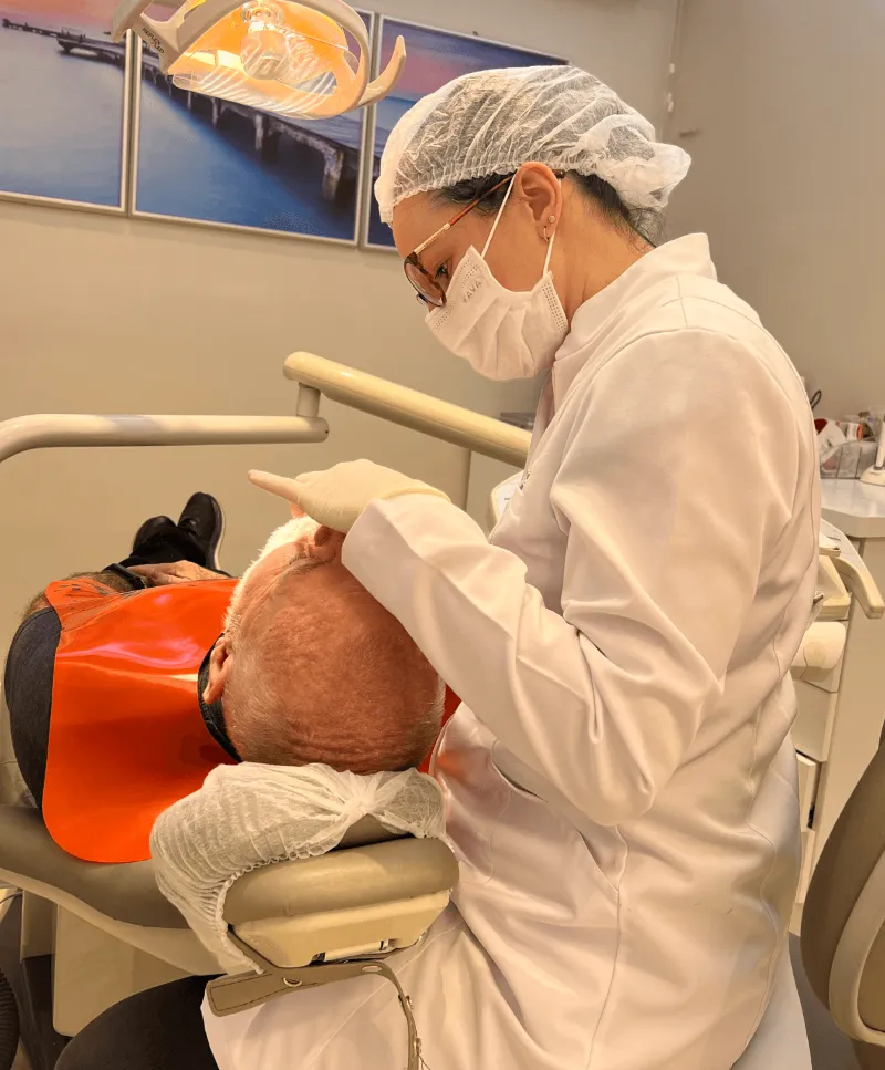 Dentista da Clínica Huk em atendimento ao paciente