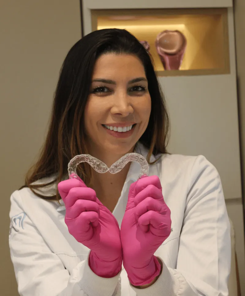 Dentista da Clínica Huk segurando alinhadores ortodônticos transparentes